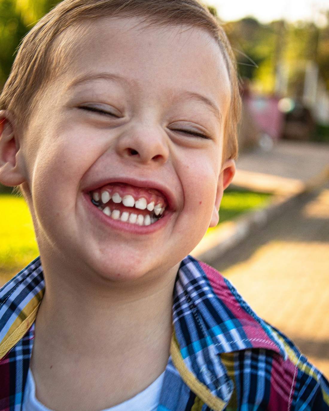 A laughing boy with Down syndrome outdoors
