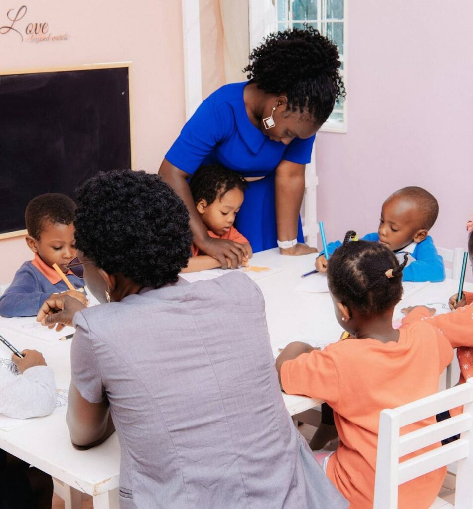 A teacher working with a group of preschool children around a classroom table